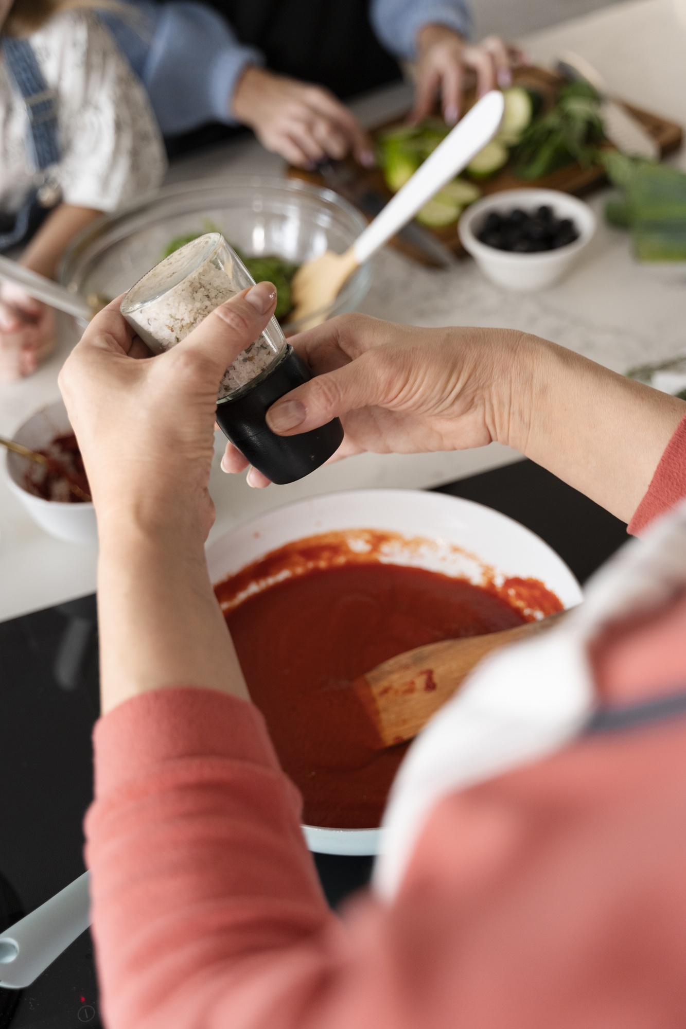 Participant seasoning a dish in workshop